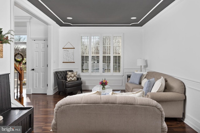 living room featuring wainscoting, wood finished floors, crown molding, and a decorative wall