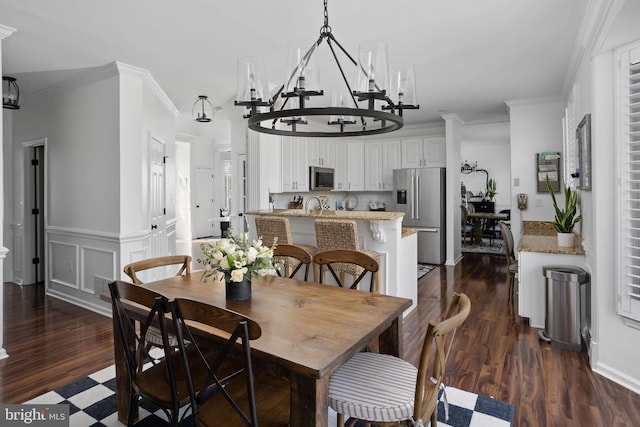 dining area with dark wood finished floors, visible vents, wainscoting, and ornamental molding