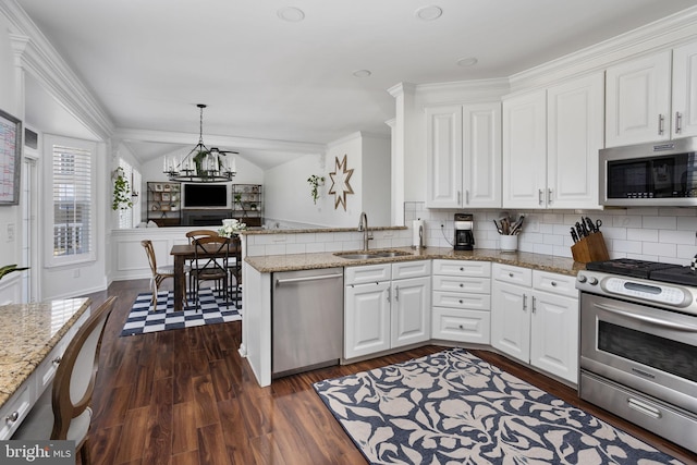 kitchen with dark wood-type flooring, a sink, white cabinetry, stainless steel appliances, and lofted ceiling