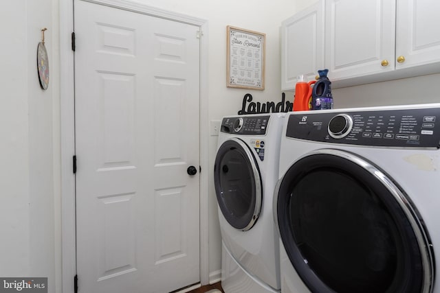 washroom featuring cabinet space and washing machine and clothes dryer