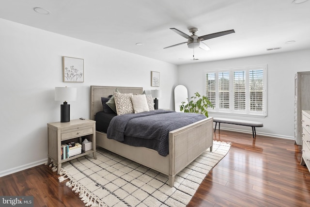 bedroom with visible vents, wood finished floors, baseboards, and ceiling fan