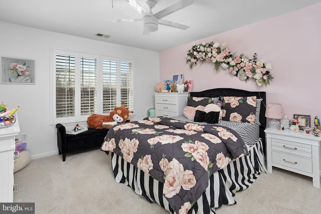 carpeted bedroom featuring a ceiling fan, visible vents, and baseboards