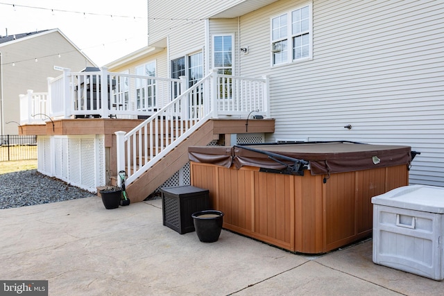 view of patio / terrace featuring a wooden deck, stairway, and a hot tub