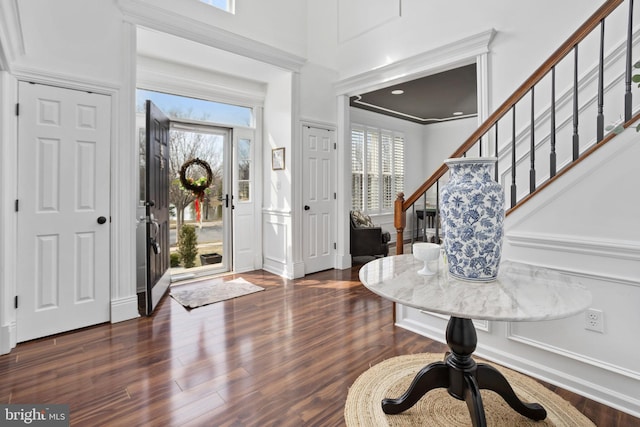 foyer entrance featuring dark wood-style floors, plenty of natural light, and stairs