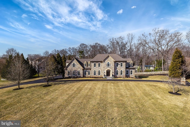 view of front of property featuring stone siding and a front lawn