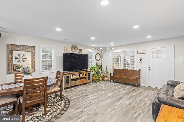 living room featuring visible vents, baseboards, light wood-style flooring, and recessed lighting