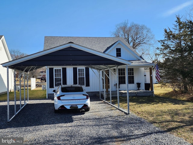 view of front facade with board and batten siding, a shingled roof, a carport, and gravel driveway