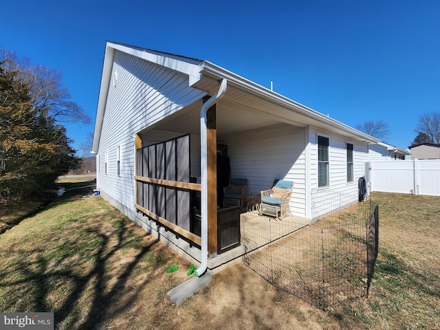 view of side of property featuring fence, a patio, and a yard