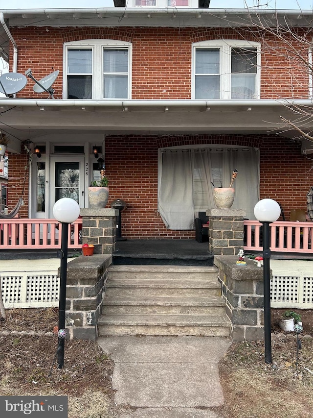 view of front facade featuring a porch and brick siding