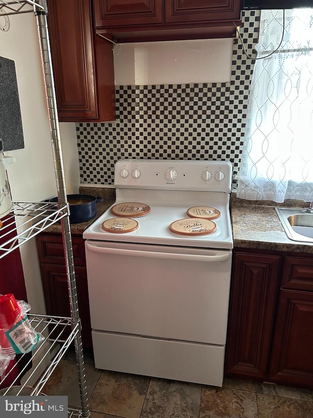 kitchen featuring dark countertops, a sink, white electric stove, and decorative backsplash