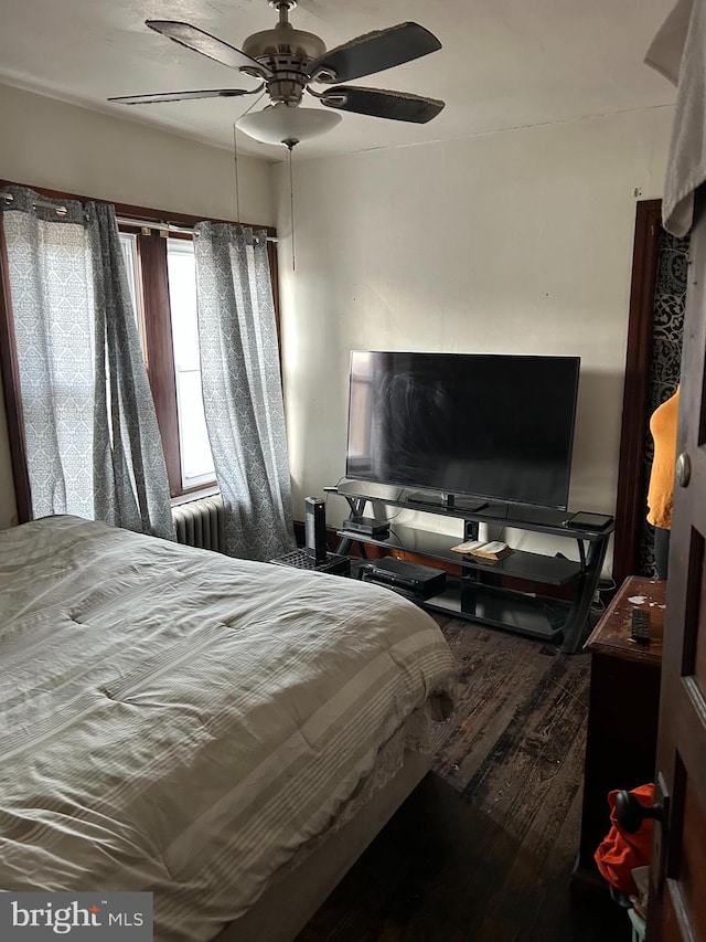 bedroom featuring ceiling fan, wood finished floors, and radiator