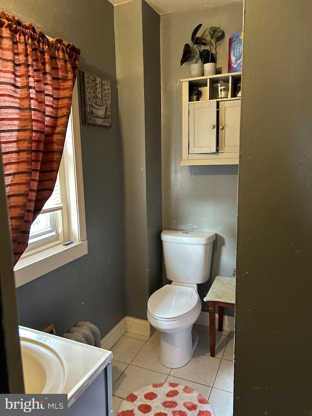 bathroom with baseboards, vanity, toilet, and tile patterned floors