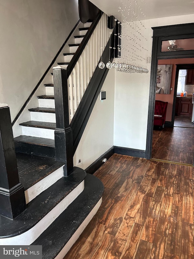 stairway featuring baseboards and wood finished floors