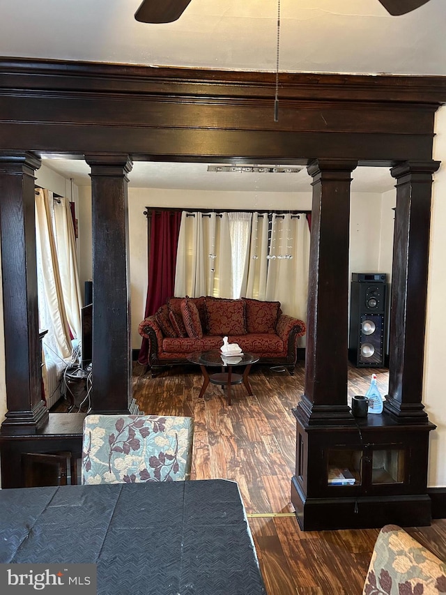 living room featuring ornate columns and wood finished floors