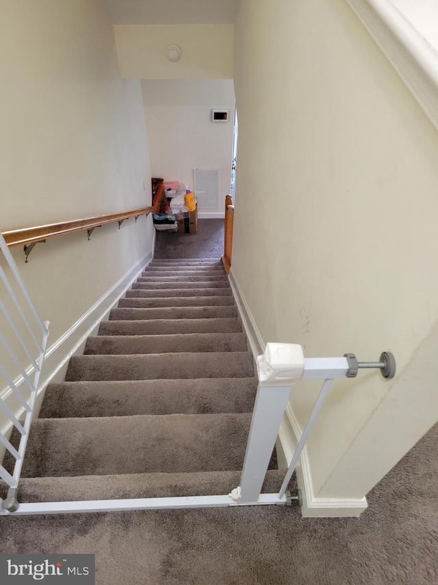 stairs featuring carpet flooring, visible vents, and baseboards