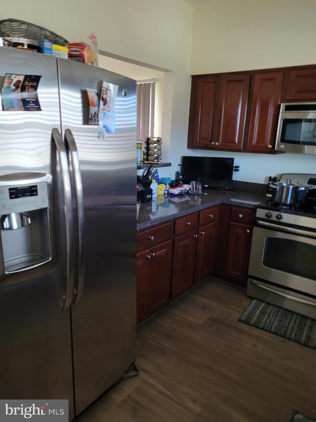 kitchen featuring appliances with stainless steel finishes, dark brown cabinets, and dark wood-style flooring