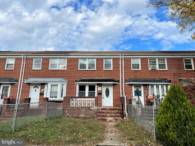 view of property featuring brick siding and a fenced front yard