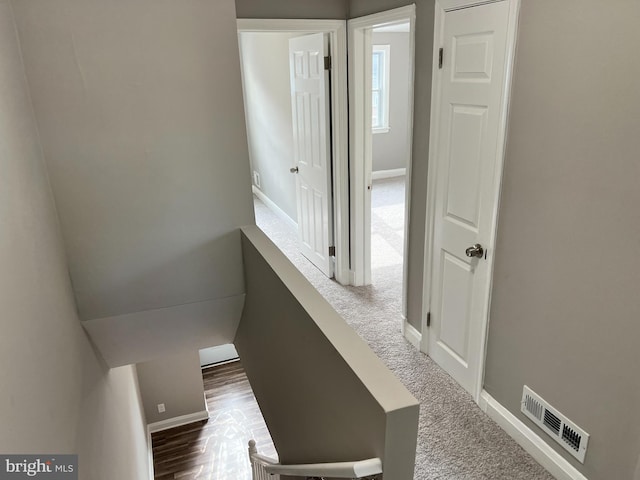 corridor with baseboards and visible vents