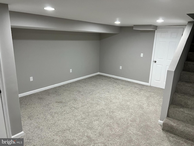 finished basement featuring carpet floors, stairs, baseboards, and recessed lighting