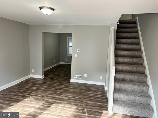 interior space with baseboards, visible vents, and wood finished floors