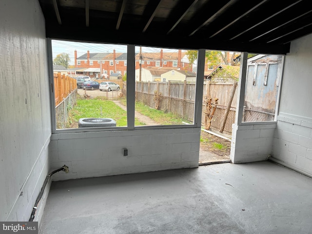 unfurnished sunroom with a residential view and a wealth of natural light