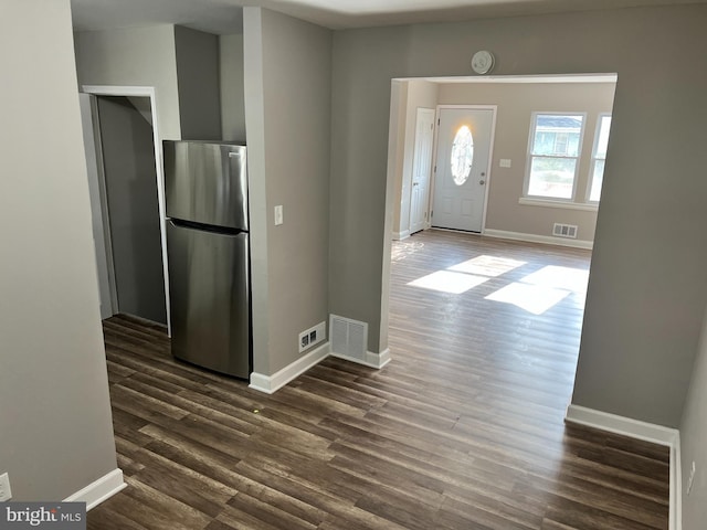 kitchen with visible vents, dark wood-style floors, freestanding refrigerator, and baseboards