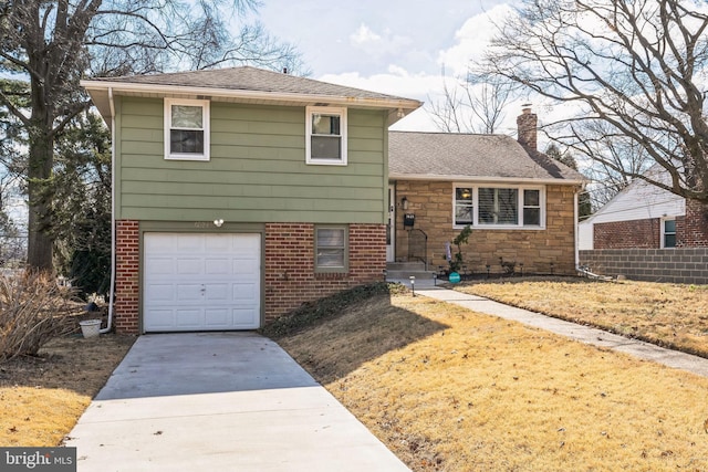 tri-level home featuring a garage, driveway, a chimney, roof with shingles, and brick siding