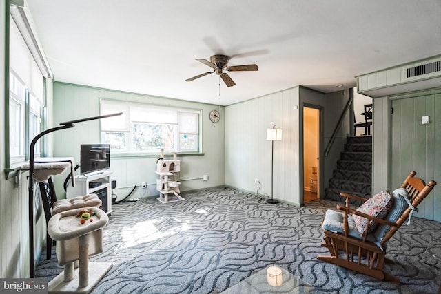 living area featuring stairs, carpet floors, and ceiling fan