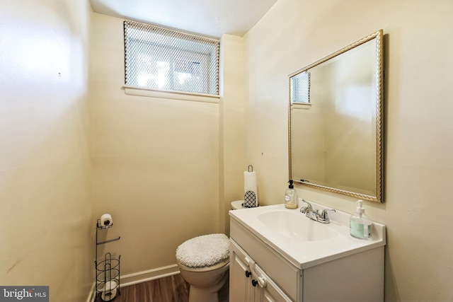 bathroom featuring baseboards, vanity, toilet, and wood finished floors