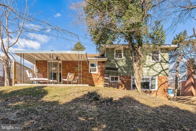 view of front facade with a front yard, covered porch, and brick siding