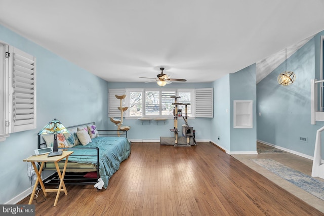 sitting room featuring ceiling fan, wood-type flooring, visible vents, and baseboards