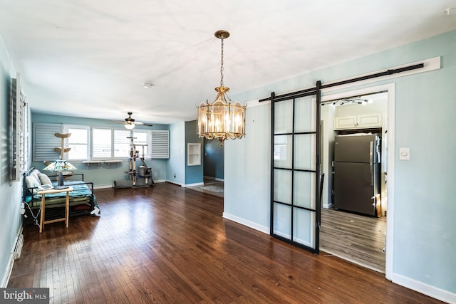 interior space with hardwood / wood-style flooring, a barn door, baseboards, and ceiling fan