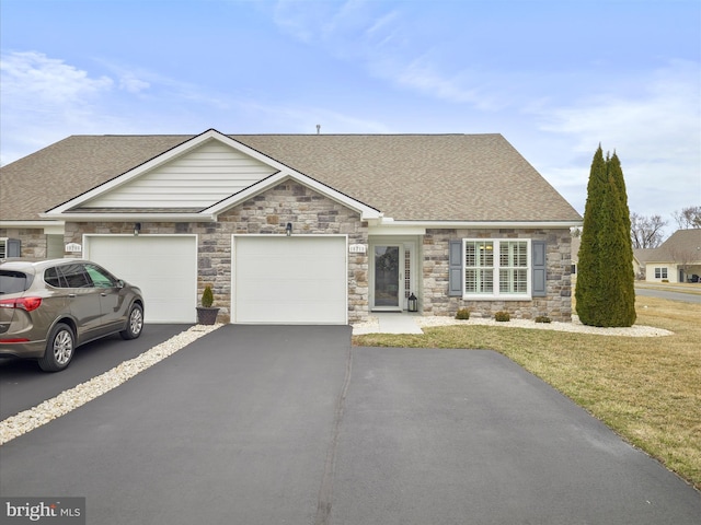 view of front of house with driveway, an attached garage, a front lawn, and a shingled roof