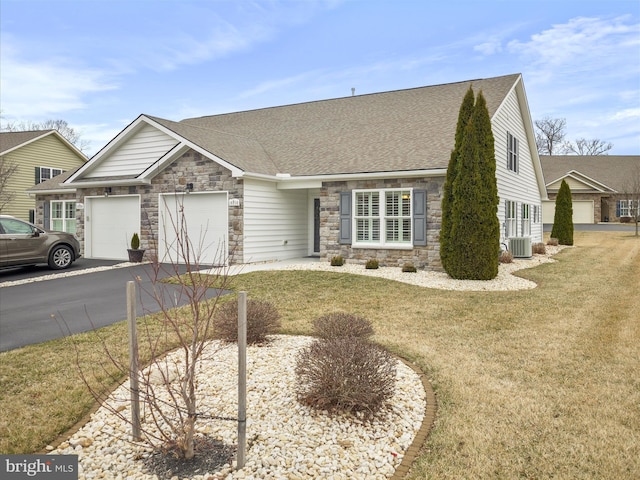 view of front of home featuring aphalt driveway, stone siding, a shingled roof, and a garage