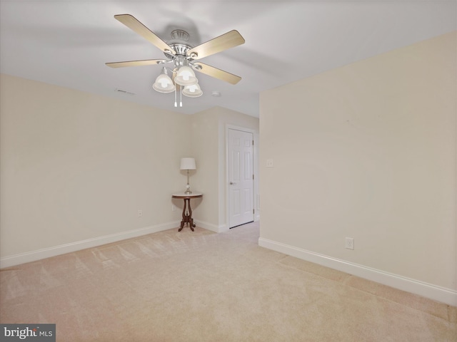 empty room with light carpet, ceiling fan, visible vents, and baseboards