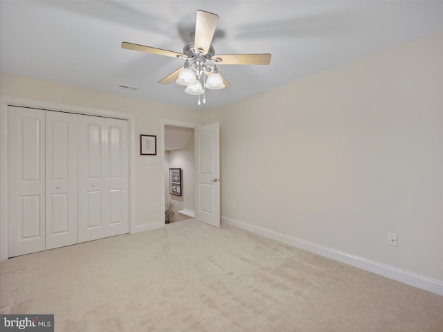 unfurnished bedroom with carpet, a closet, ceiling fan, and baseboards