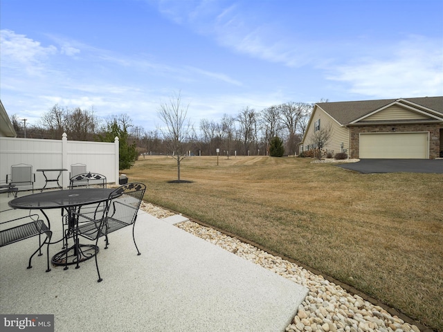 view of yard featuring outdoor dining space, a patio area, and fence