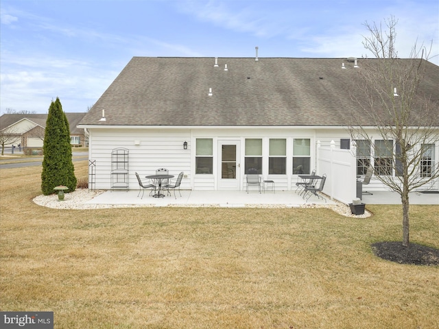 back of house with a patio area, a yard, and roof with shingles