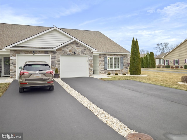 view of front of house with a shingled roof, a front lawn, driveway, and an attached garage