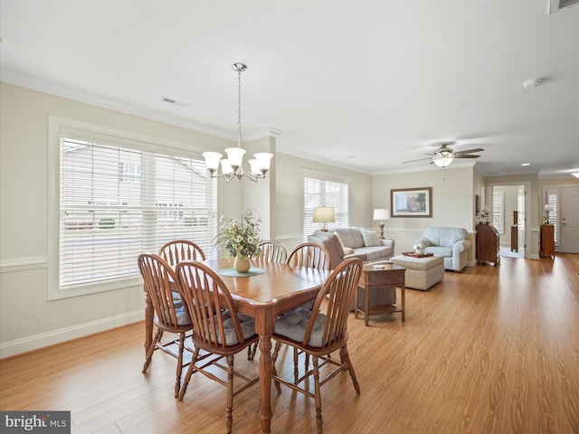 dining space featuring light wood-style floors, plenty of natural light, and crown molding