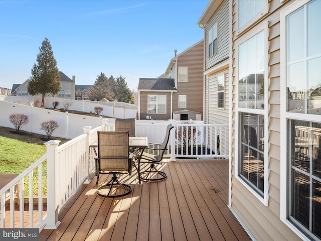 deck with outdoor dining area, fence private yard, and a residential view