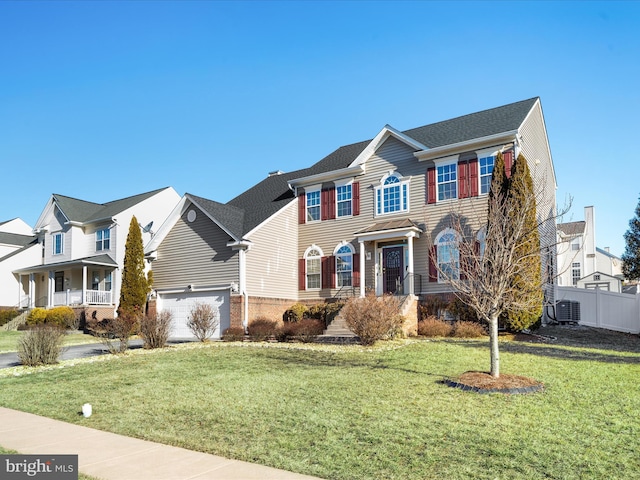 colonial house with a residential view, fence, a front lawn, and cooling unit