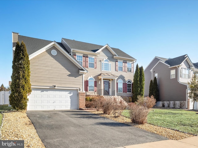 view of front of home featuring a front yard, brick siding, driveway, and an attached garage