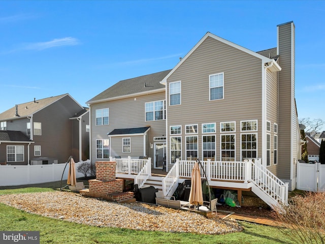 back of house with stairs, a chimney, fence, and a deck