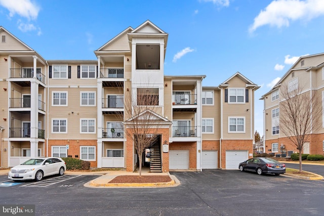 view of property with a garage and uncovered parking