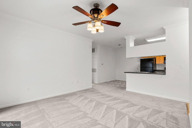 unfurnished living room featuring light carpet, ceiling fan, ornamental molding, and baseboards