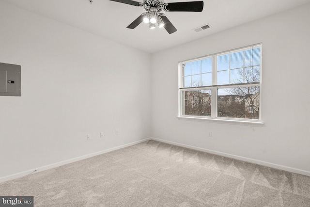 empty room with carpet floors, baseboards, electric panel, and visible vents