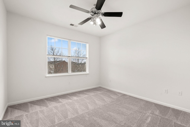 spare room with a ceiling fan, baseboards, visible vents, and carpet flooring