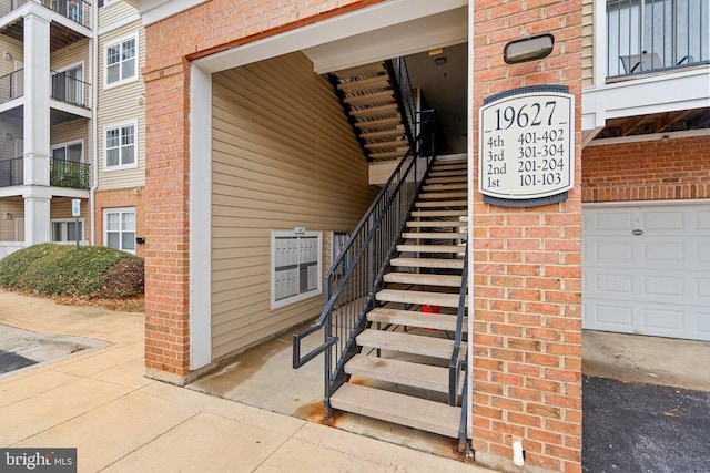 property entrance featuring a garage and brick siding