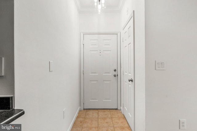 doorway to outside with ornamental molding, baseboards, and light tile patterned floors